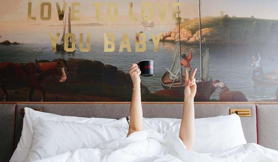 Silly Person in Bed Making Peace Sign With Hands